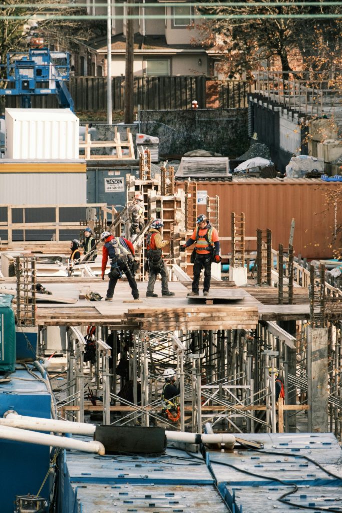 A group of men standing on top of a building under construction